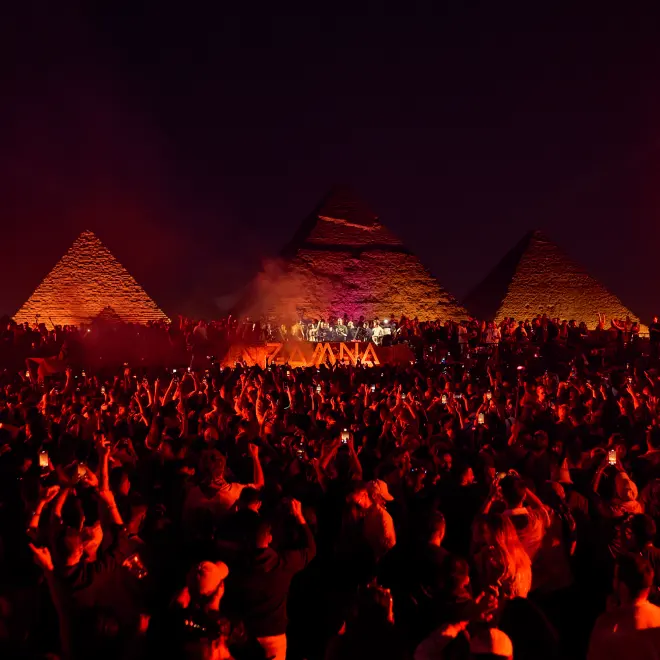 Zamna Egypt crowd dancing beneath illuminated pyramids